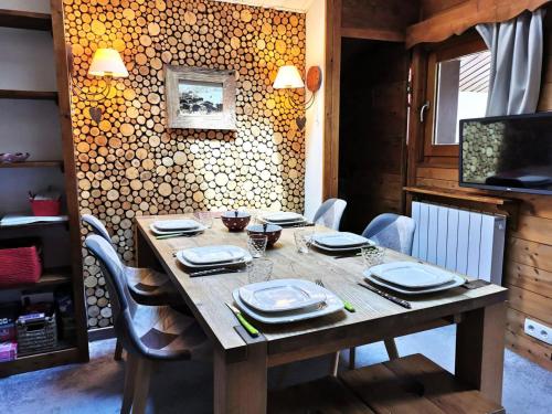 - une table en bois avec des assiettes et de la vaisselle dans l'établissement Résidence Fagot - Le Fagot 15 - Appartement rénové avec goût, proche pistes et commerces MAE-1701, à Valmorel