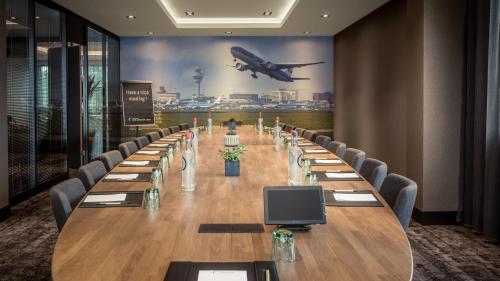 a long table with chairs and an airplane on the wall at Van der Valk Hotel Sassenheim - Leiden in Sassenheim