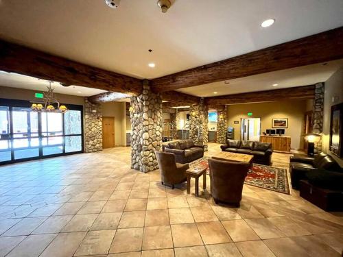 a large living room with couches and a stone wall at MT CB Mountain Side with King Bed, Hot Tub, Pool & Kitchen! in Crested Butte