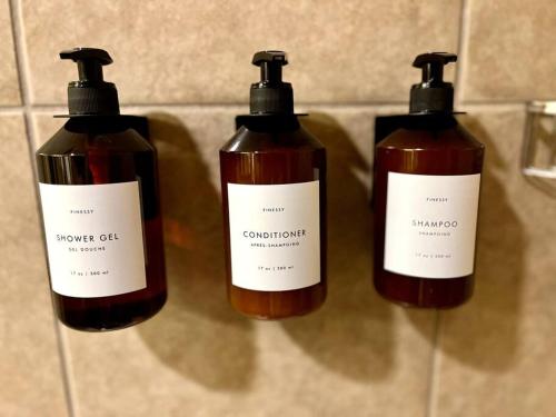 a group of three bottles of soap on a wall at MT CB Mountain Side with King Bed, Hot Tub, Pool & Kitchen! in Crested Butte