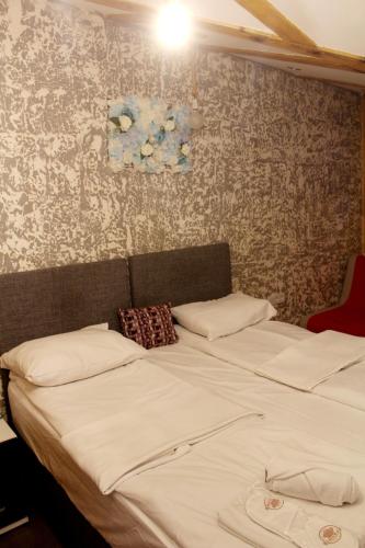 a bedroom with two beds and a wall with wallpaper at Sebilhan Apart Hotel in Sarajevo