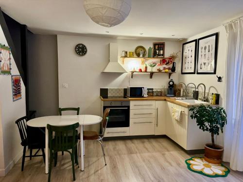 a kitchen with a table and a table and chairs at Au Canon - Parking gratuit - Bords de Loire in Orléans