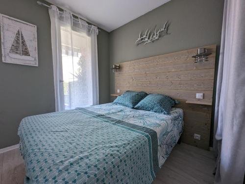 une chambre avec un lit et une grande fenêtre dans l'établissement Appartement bord de mer, piscine et Wifi, à Saint-Cyprien