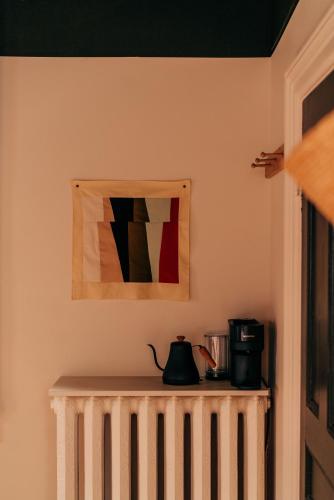 una mesa con cafetera y una foto en la pared en Somewhere Inn Collingwood, en Collingwood