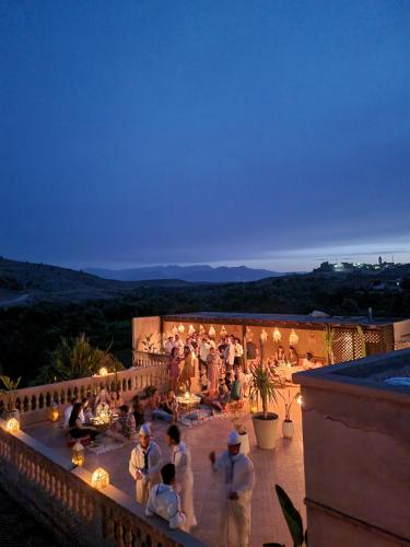 ララ・タクルクストにあるLes terrasses du Lac Marrakechの夜のバルコニーに立つ人々