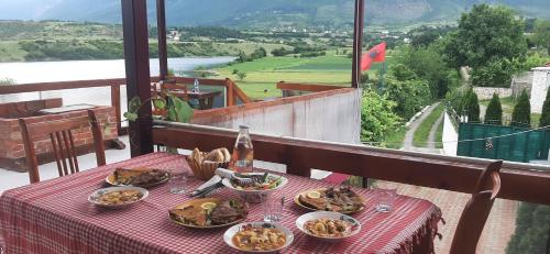 einen Tisch mit Teller mit Speisen auf dem Balkon in der Unterkunft SuperPanorama GuestHouse in Kukës