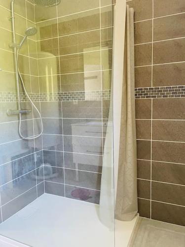 une salle de bain avec une douche avec une porte vitrée dans l'établissement Maison 6 personnes piscine privée proche Sarlat, à Proissans