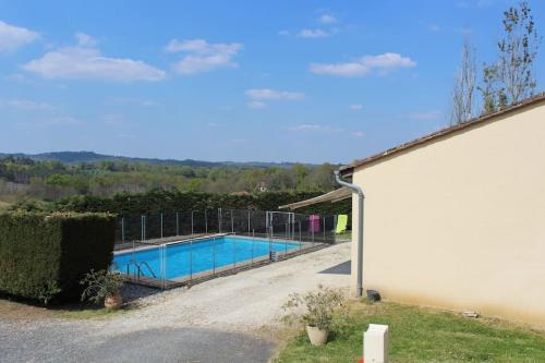 - une piscine à côté d'un bâtiment blanc dans l'établissement Maison 6 personnes piscine privée proche Sarlat, à Proissans