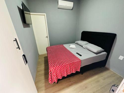a small room with a bed with a red and white table cloth at On Park Hotel e Traslado in Guarulhos