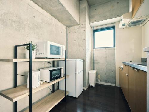 a small kitchen with a refrigerator and a microwave at vetta KumamotoCastle602 in Kumamoto
