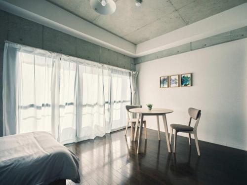 a bedroom with a table and two chairs and a bed at vetta KumamotoCastle602 in Kumamoto