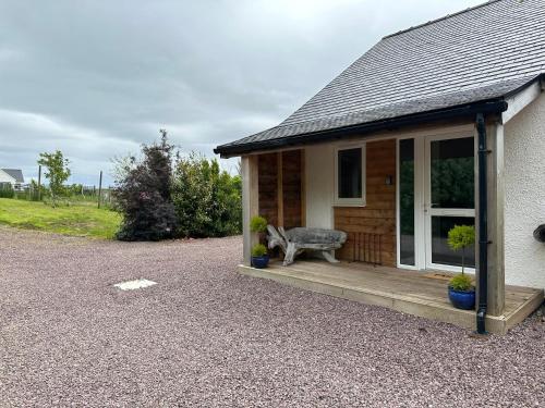 a dog sitting on a porch of a house at Antlers Rest in Borve