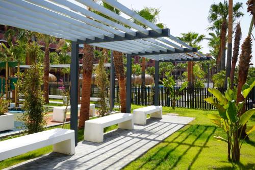 a row of white benches under a blue pergola at Playa Granada Apartamentos Moriscos II in Motril