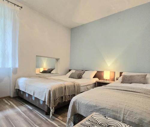 1 dormitorio con 2 camas y espejo en la pared en Willa Jagiellonka apartamenty w centrum, parking, en Zakopane