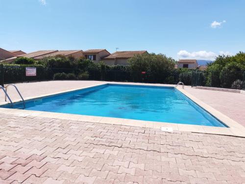 une piscine avec de l'eau bleue dans une cour dans l'établissement Appartement bord de mer, piscine et Wifi, à Saint-Cyprien