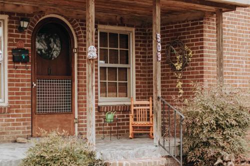 a brick house with a door and two chairs at Fairy House by Eden Crest in Sevierville