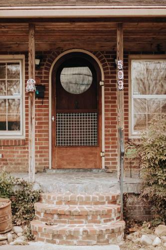 a brick house with a wooden door and stairs at Fairy House by Eden Crest in Sevierville