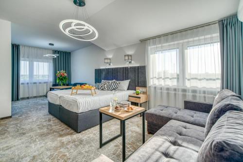 sala de estar con cama y sofá en Acodomo Apartamenty, en Poddębice