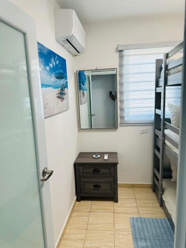 a bathroom with a mirror and a wooden table at New! Mini Casa de Playa in Arecibo