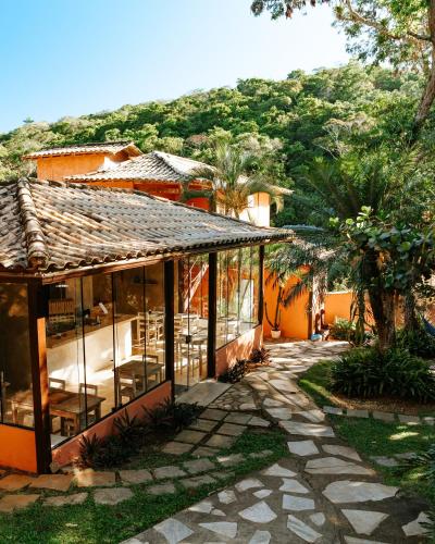 a house with a patio and a mountain in the background at Pousada Casa Cactus Praia da Tartaruga Búzios in Búzios