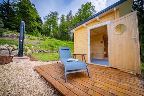 a blue chair sitting on a wooden deck next to a building at Sonnenhäusle - Natur. Fernblick. Panorama-Sauna. in Sasbachwalden
