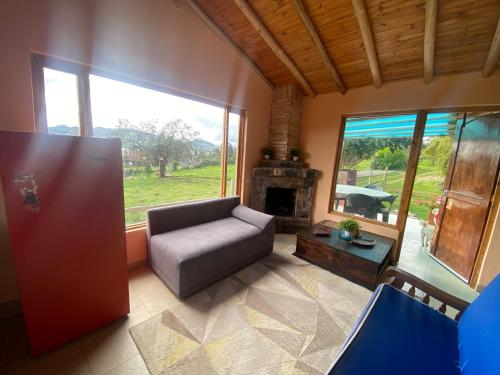 uma sala de estar com um sofá e uma lareira em Rancho New Life Guatavita em Guatavita