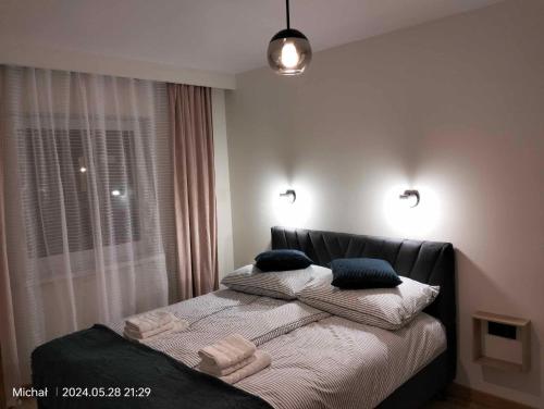 a bedroom with a bed with two pillows on it at Apartament na Glinkach 22 in Augustów