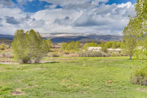 a field with trees and mountains in the background at Near Trail Dtwn Eagle Ranch Condo with Balcony in Eagle