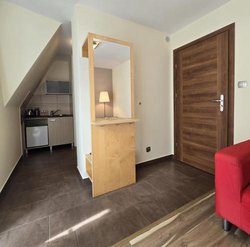 sala de estar con sofá rojo y puerta de madera en Willa Jagiellonka apartamenty w centrum, parking, en Zakopane