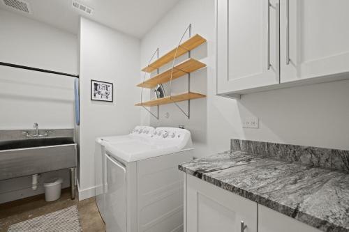 a white kitchen with a sink and a counter at Terracotta Bliss Wimberley Retreat For 28 Guests in Wimberley