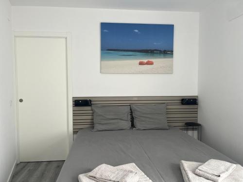a bedroom with a bed with two towels on it at Apartamento Brisa do Mar in Sesimbra
