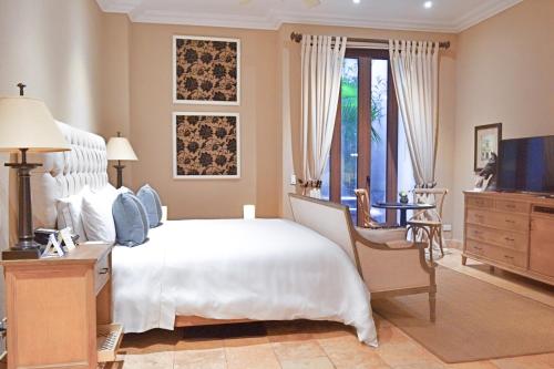 a bedroom with a bed and a dresser and a television at Bastión Luxury Hotel in Cartagena de Indias
