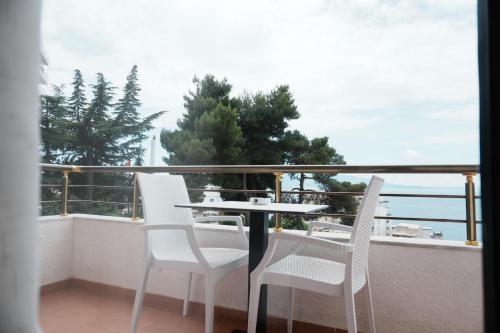 a table and chairs on a balcony with a view of the ocean at Hotel Mediterrane in Sarandë