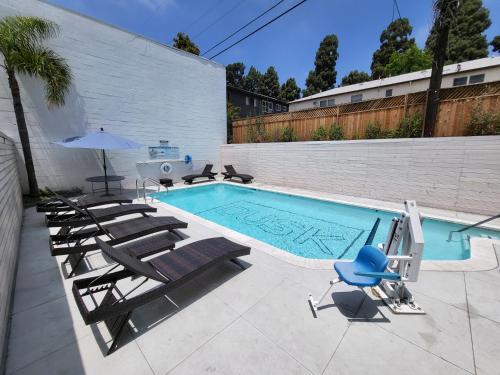 una piscina con sedie a sdraio e ombrellone di Dusk Hotel Hollywood a Los Angeles