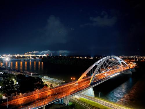 a bridge over a river at night at Danube river front, SKYSCRAPER Bratislava in Bratislava