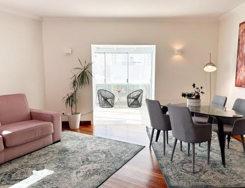 een woonkamer met een bank en een tafel en stoelen bij Oriente 25 Housing by APT IIN in Lissabon
