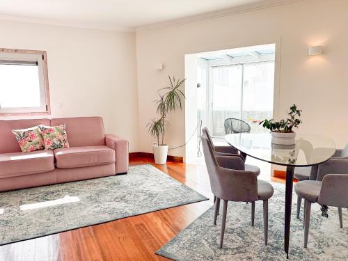 a living room with a pink couch and a glass table at Oriente 25 Apartments by APT IIN - Parque das Nações in Lisbon