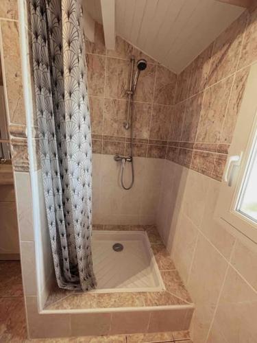 une salle de bain avec une douche avec un rideau de douche dans l'établissement Villa familiale 8 personnes, piscine chauffée à 10 kms de la mer, à Saubion