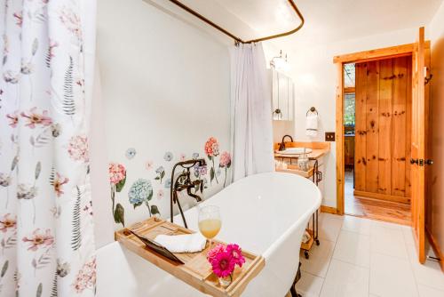 een badkamer met een bad en een douchegordijn bij Alexandria Cabin with Patio, Grill and Deck 