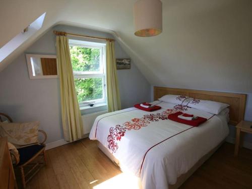 Un dormitorio con una gran cama blanca con ventana. en The Tree House, en Whitby