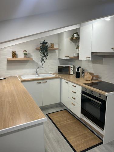 a kitchen with white cabinets and a sink and a stove at Loft Nazare Waves in Nazaré