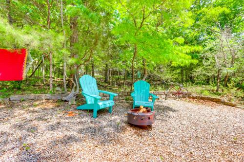 two blue chairs sitting next to a fire in a yard at Hot Tub and Fire Pit Holiday Island Getaway! in Golden