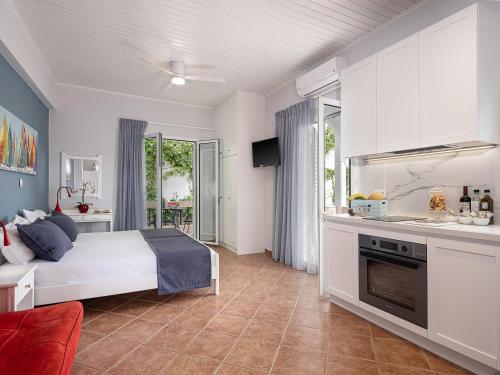 a living room with a bed and a kitchen at Elena Seafront Luxury Apartments in Almirida