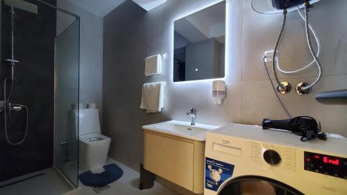 łazienka z umywalką i pralką w obiekcie Luki's Centre Apartment w Prisztinie
