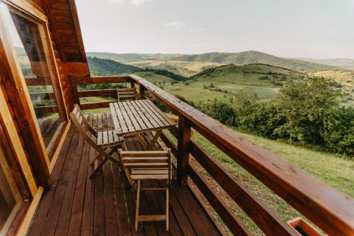 a wooden deck with a table and chairs on it at Uvacki raj in Radijevići