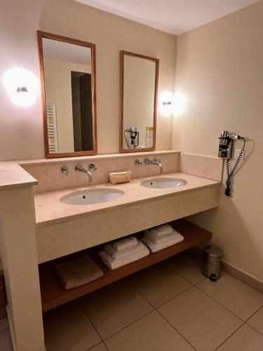 une salle de bain avec deux lavabos et deux miroirs dans l'établissement SUITE Supérieure Domaine du Golf St Endreol, 1 à 2 personnes, à La Motte