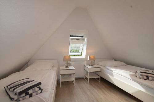 two twin beds in a room with a window at Rüm Hart II, Weestersir in Hörnum