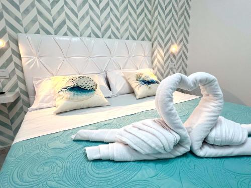 Una cama con dos cisnes hechos de toallas. en Encantador Apartamento con Terraza, Los Cristianos, en Los Cristianos