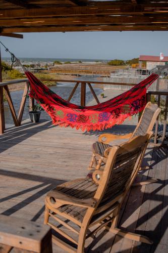 a hammock and a chair on a dock at Watu Kite House in Mayapo