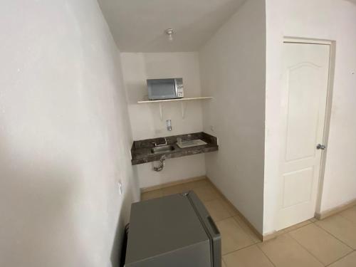 a small white room with a microwave and a door at Apartamentos Amplios Alfa # 238 in Monterrey